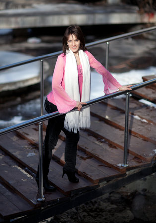 Beautiful girl in a pink blouse on stairsの写真素材