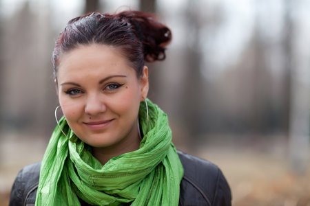 Portrait girl in a green scarf in the parkの写真素材