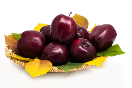 Basket of dark red apples on a white backgroundの写真素材
