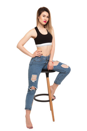 Sitting girl in a chair on a white backgroundの写真素材