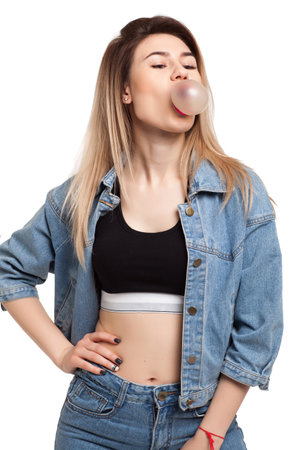 Girl blowing a ball of chewing gumの写真素材