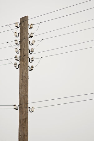Photo of wooden power poles with wires and insulatorsの写真素材