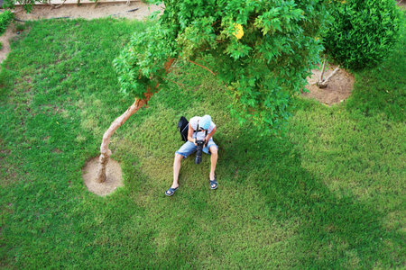 man lying on green field and photographsの写真素材