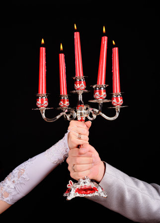 Bride and groom hands with candlesの写真素材