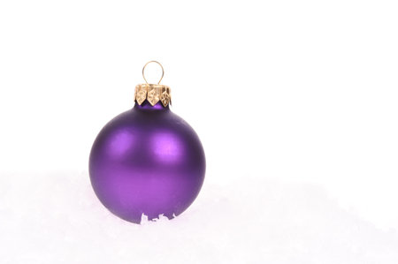 purple christmas ball with snow on white background の写真素材