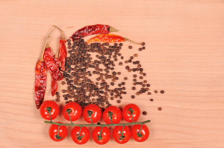 Black pepper red pepper and tomato  on the wooden cutting board