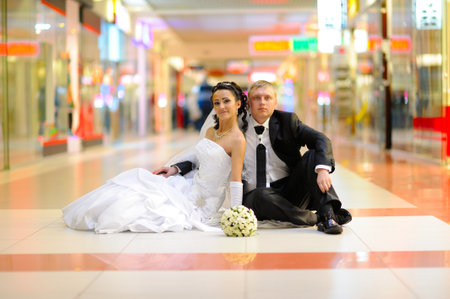 Bride and groom sitting on the floorの写真素材