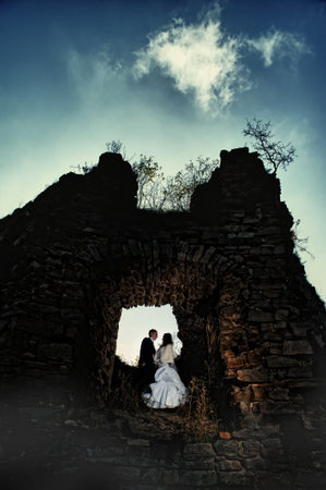 Bride and groom kissing in the ancient castleの写真素材