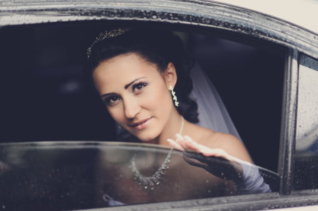 Young attractive bride gazing through the window of a vehicleの写真素材