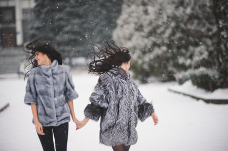 funny girls enjoying winter weather  - with film effect with small grainの写真素材