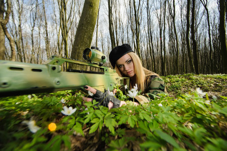 Beautiful army girl with gun  outdoor in the forest