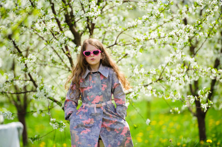 Portrait of Little pretty girl in the green blooming gardenの写真素材
