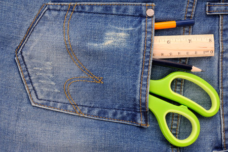 Scissors ruler and pencil in  the blue jeans back pocket