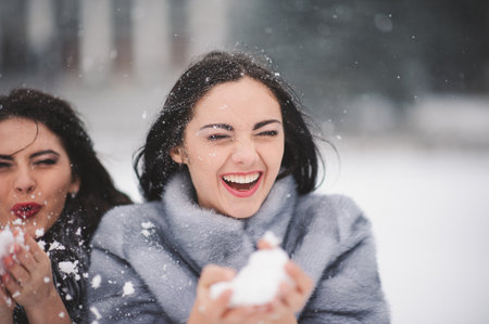 funny girls enjoying winter weather  - with film effect with small grain