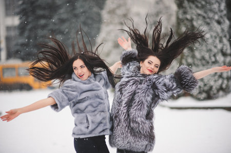 funny girls enjoying winter weather  - with film effect with small grain