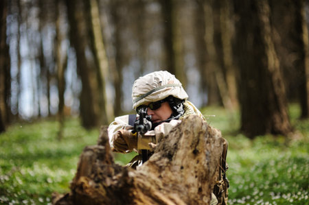 army girl with gun  outdoor in the forestの写真素材