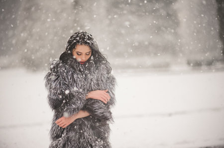 winter portrait of Beauty girl with snow - with film effect with small grainの写真素材