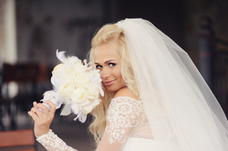 Beautiful bride with bouquet of flowers outdoorの写真素材