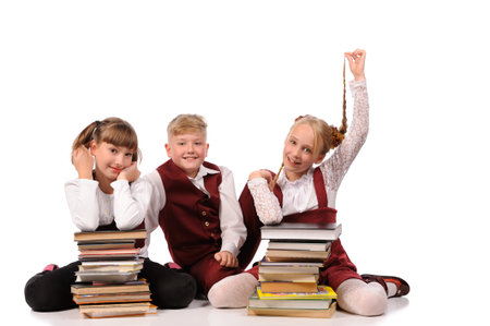 happy children with books siiting on the floor isolated over white backgroundの写真素材