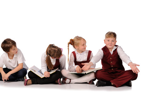 happy children with books siiting on the floor isolated over white backgroundの写真素材