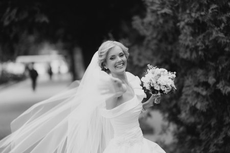 Beautiful bride with bouquet of flowers outdoorの写真素材