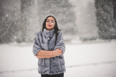 winter portrait of Beauty girl with snow - with film effect with small grainの写真素材