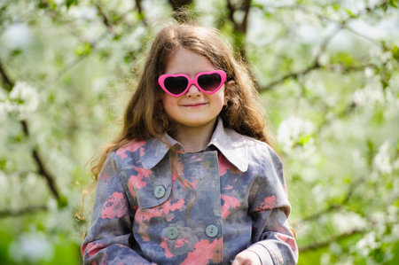 Portrait of Little pretty girl in the green blooming gardenの写真素材