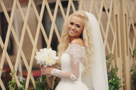 Beautiful bride with bouquet of flowers outdoorの写真素材