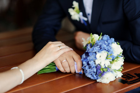 Happy bride and groom hold handsの写真素材