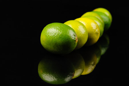 green and yellow lemons on the black background