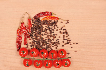 Black pepper red pepper and tomato  on the wooden cutting boardの写真素材