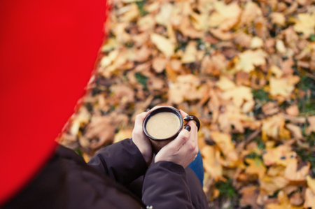 Lady in park, drinking coffee to goの写真素材