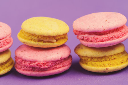 Sweet and colourful french macaroons or macaron on the purple backgroundの写真素材