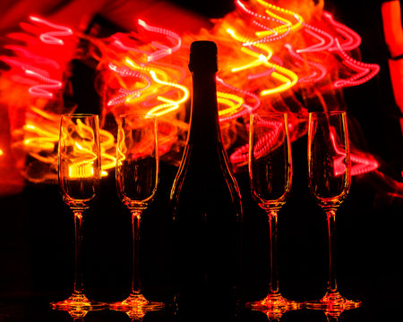 Glasses of champagne on bright background with bokeh effect. Cheersの写真素材