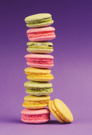 Sweet and colourful french macaroons or macaron on the purple backgroundの写真素材