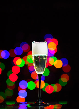 Glass of champagne on bright background with bokeh effectの写真素材
