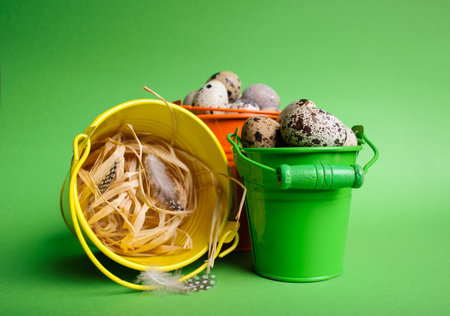 Small decorative buckets filled quail eggs on the green backgroundの写真素材