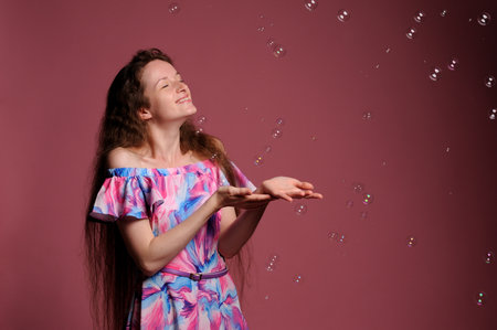 portrait of pretty woman in pink dress over grey backgroundの写真素材