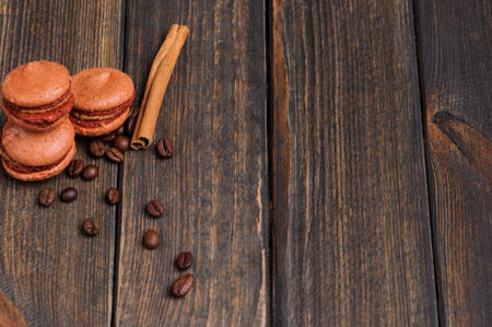 Sweet and colourful french macaroons with coffee beans on the wooden backgroundの写真素材