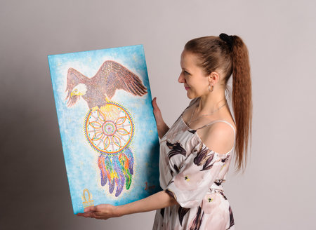 artist with own picture over grey backgroundの写真素材