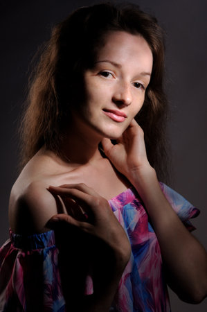 portrait of pretty woman in pink dress over grey backgroundの写真素材