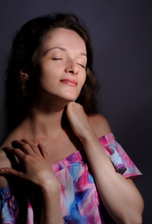 portrait of pretty woman in pink dress over grey backgroundの写真素材