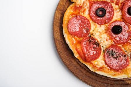Delicious pizza served on wooden plate isolated on whiteの写真素材