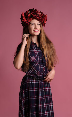 beatiful girl with a wine-colored wreath in studio over pink backgroundの写真素材