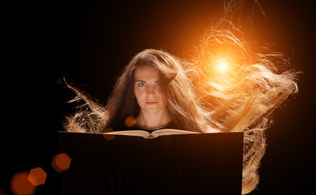 Magic Woman reading a book. black backgroundの写真素材