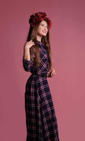 beatiful girl with a wine-colored wreath in studio over pink backgroundの写真素材