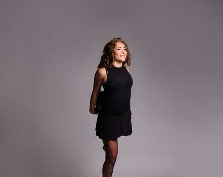 Young beautiful dancer gymnastics posing in studio with ball over grey backgroundの写真素材