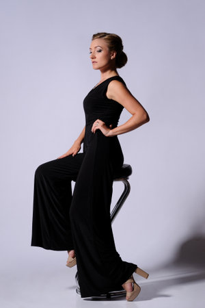 fashion picture of beautiful young blonde woman wearing black dress nice makeup. Studio picture, grey backgroundの写真素材