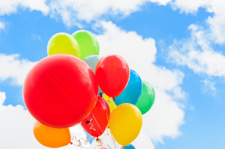 Bright colorful balloons over blue sky backgroundの写真素材