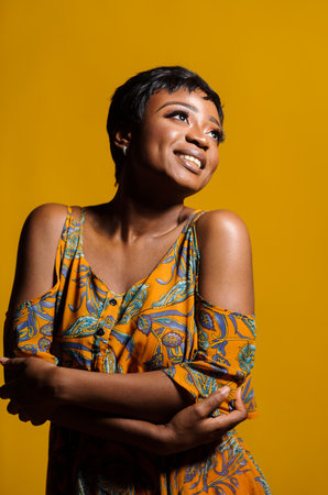 Portrait of a beautiful young African woman over yellow background. Studio pictureの写真素材
